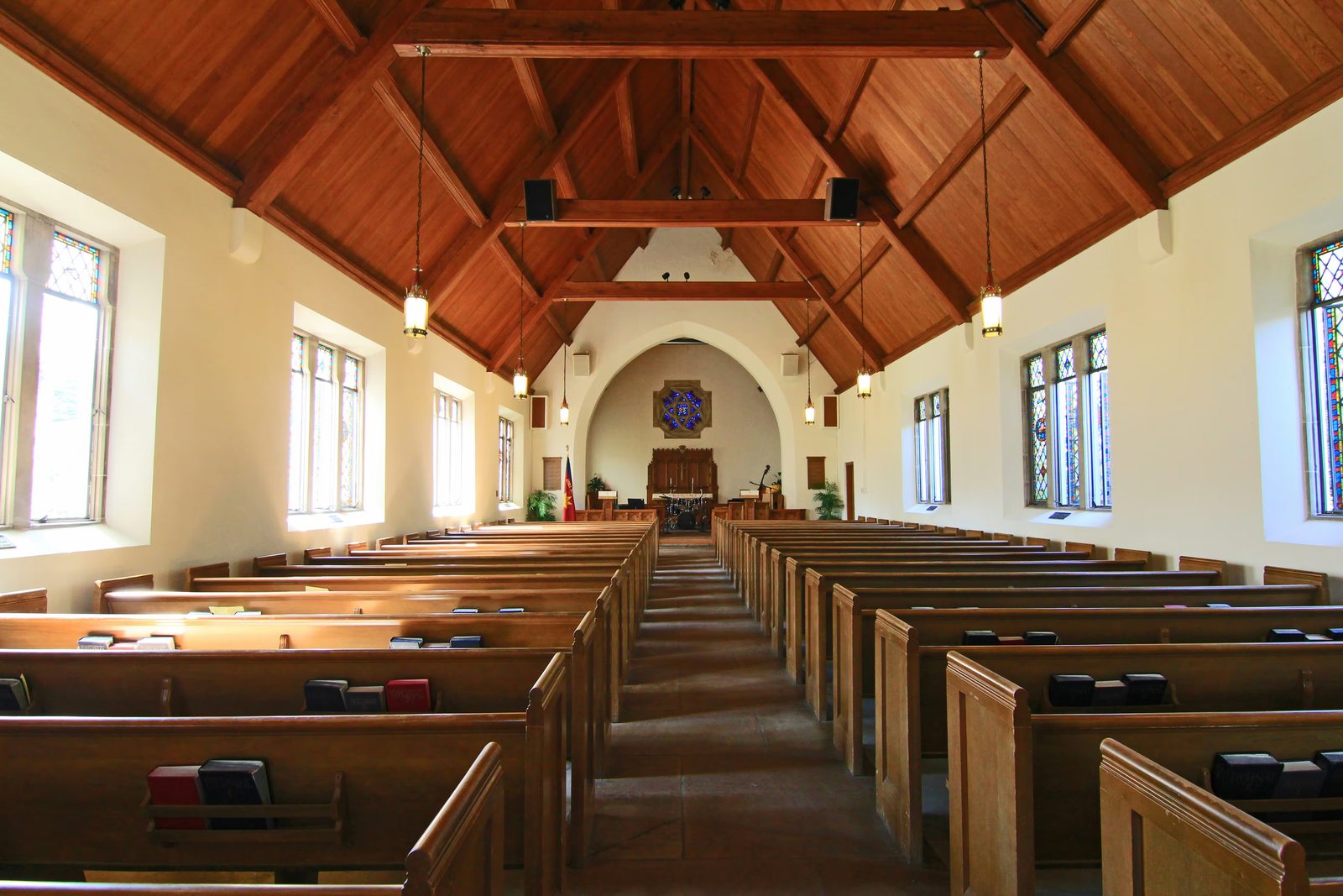 Church sanctuary with wooden pews and stained glass windows