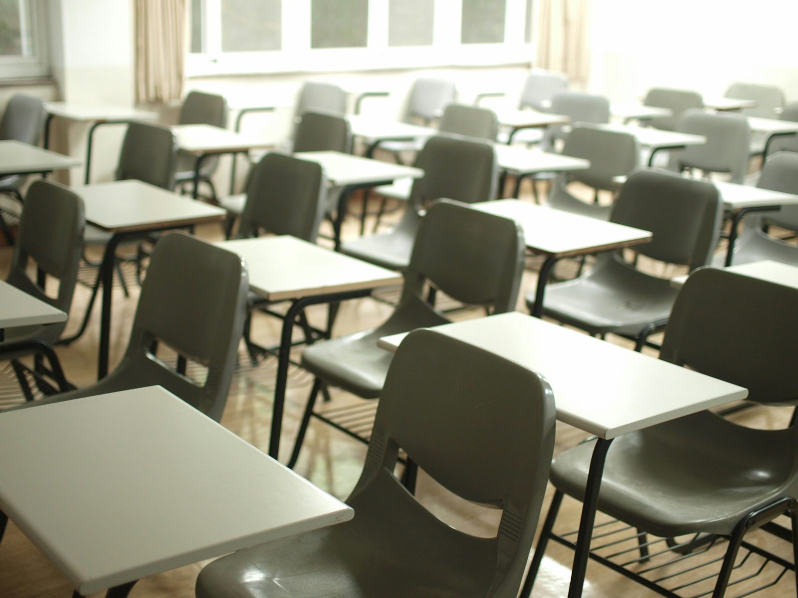 Empty classroom with rows of desks in natural light